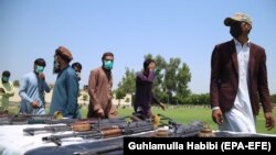 Former militants surrender their weapons during a reconciliation ceremony in Jalalabad on June 25. Many Afghans worry that the impending peace talks will not protect human rights should the hard-line group regain a role in power.