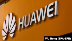 Илустрација- логото на Хуавеи пред продавница во Кина