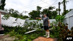 Мъж сочи към разрушения покрив в задния си двор след удара на торнадо във Форт Майерс, Флорида на 9 октомври 2024 г., докато ураганът "Милтън" наближава.