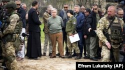 UN Secretary-General Antonio Guterres (center) stands at the site of a mass grave in Bucha, on the outskirts of Kyiv, during a visit on April 28.