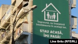 Panou publicitar cu îndemnul de a sta acasă pe un bloc din Chișinău