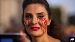 A woman with her face painted takes part in a protest against the crackdown by Iranian authorities in London on October 29.