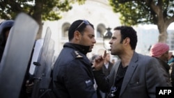 Demonstrant se raspravlja sa policajcem tijekom prosvjeda u centru Tunisa, 17. siječanj 2011.
