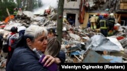 Киевляне возле разрушенного во время российской атаки дома. 31 июля 2025 года