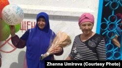 Освободившаяся из тюрьмы 37-летняя Жанна Умирова (слева) с матерью Куляш Умировой на фоне женской тюрьмы (учреждение ЛА-155/4) близ Алматы. Поселок Жаугашты Алматинской области, 19 августа 2019 года.