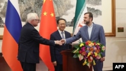 Ministrul adjunct de externe al Rusiei, Serghei Reabkov (stânga), viceministrul executiv al afacerilor externe al Chinei, Ma Zhaoxu (centru), și ministrul adjunct de externe al Iranului, Kazem Gharibabadi, susțin o conferință de presă la Beijing, pe 14 martie.