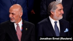 FILE: Afghan President Ashraf Ghani (L) and former Chief Executive Abdullah Abdullah during a NATO Summit in Warsaw in July 2016.