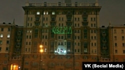 Здание посольства США в Москве, подсвеченное антиамериканской надписью