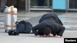 FILE: An Afghan, whose asylum application was been rejected, kisses the ground after he arrived from Germany in Kabul airport in December, 2016.