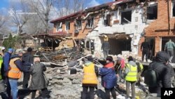 Stanovnici ukrajinskog grada Kropivnicki raščišćavaju ruševine posle ruskog napada dronovima, 20. mart 2025.