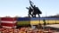 Памятник советским солдатам в Риге, окруженный забором в цветах латвийского и украинского флагов, в мае 2022 года, за три месяца до того, как он был снесен