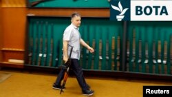 Një punëtor duke mbajtur një pushkë automatike në një sallë ekspozitash të fabrikës së armëve Zastava, në Kragujevc, më 8 maj 2013.