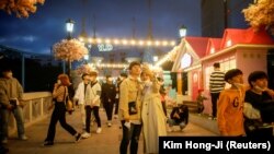 Un cuplu și-a dat job temporar măștile de protecție pentru a face o fotografie într-un parc de distracții din Seul 