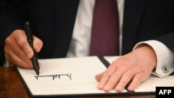 Американскиот претседател Доналд Трамп потпишува извршни наредби во Овалната соба на Белата куќа во Вашингтон, на 20 јануари 2025 година