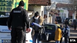 Полицай проверява документите на жителка на столичния квартал "Филиповци", където от полунощ е наложена карантина