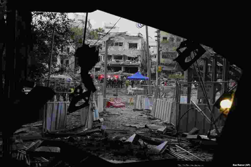 Shpëtimtarë duke punuar në vendin ku ra një raketë e lëshuar nga Irani, në Tel Aviv, më 16 qershor.
