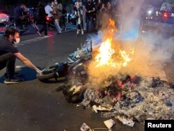 În protestele din 19 septembrie din Teheran, o motocicletă a poliției este incendiată.