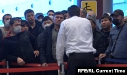 Migranți din Asia Centrală așteaptă într-un aeroport din Moscova.