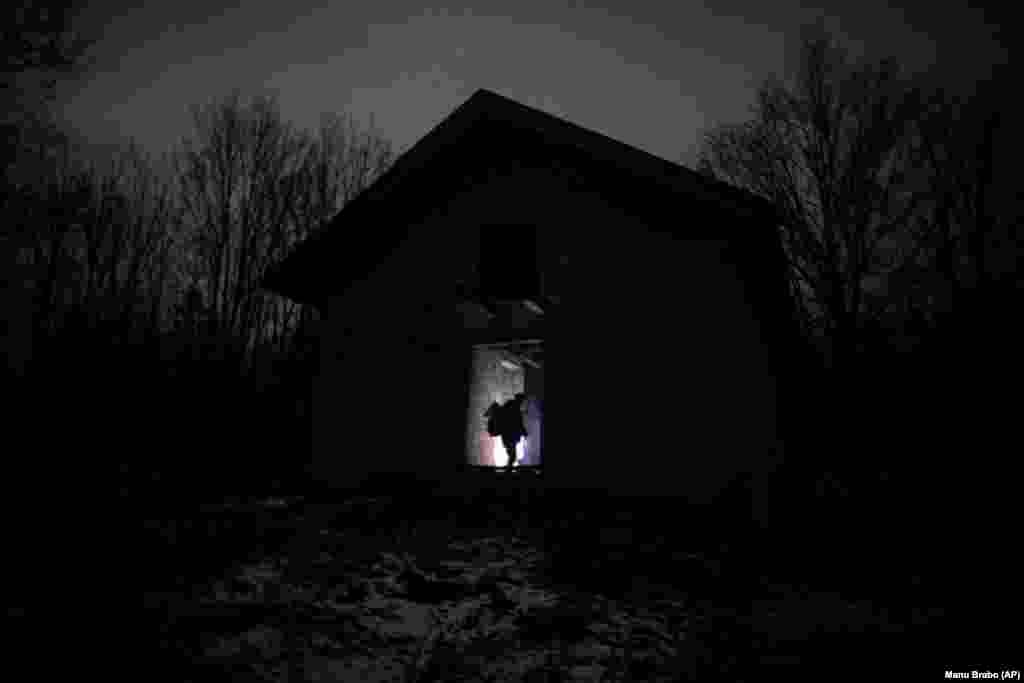 Migranti stoje pored štale prije još jednog pokuđaja da pređu u EU u blizini Bihaća.