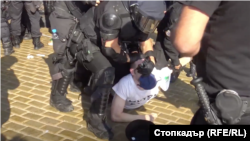 Млад мъж беше хвърлен на земята, полицай натисна с пръсти очите и носа му, главата му беше извита назад. Младежът беше държан половин час на площада, легнал по корем.