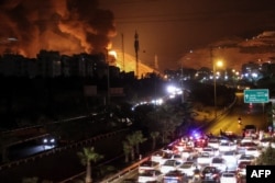 Blocaj pe autostradă la nord-vest de Teheran, în timp ce un incendiu a izbucnit în apropiere în depozitele de petrol din Shahran, pe 15 iunie 2025.