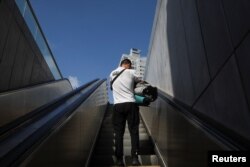 Muškarac nosi svoje stvari dok izlazi iz podzemne željezničke stanice koja je korištena kao sklonište od bombi, nakon što je na snagu stupilo primirje između Irana i Izraela u Ramat Ganu, Izrael, 24. juna 2025.