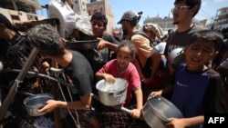 Palestinieni adunați la un punct de distribuire a alimentelor la tabăra de refugiați Nuseirat. 19 iulie 2025. 