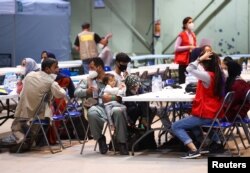 Španski i afganistanski državljani odmaraju se po dolasku u vazdušnu bazu Torrejon nakon evakuacije iz Kabula, u Torrejon de Ardozu, izvan Madrida, 19. avgusta 2021.