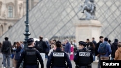 Френски полицаи патрулират близо до стъклената пирамида на Лувъра, 20 октомври 2025 г.