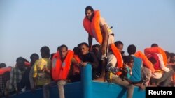 Средоземно Море - Мигранти од Еритреја на дрвен брод за време на спасувачка операција на шпанската невладина организација Проактива, во близина на либискиот брег во Средоземното Море, 29 август 2016 година