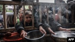 Разселени палестински деца се събират, за да получат храна в държавно училище в Рафах в южната част на Ивицата Газа 