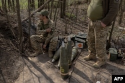 Ukrajinski vojnici iz artiljerijske jedinice puka Skala čekaju pored granata dok njihove saborci ispaljuju haubicu M109 prema ruskim položajima u istočnoj Donjeckoj oblasti 23. aprila.