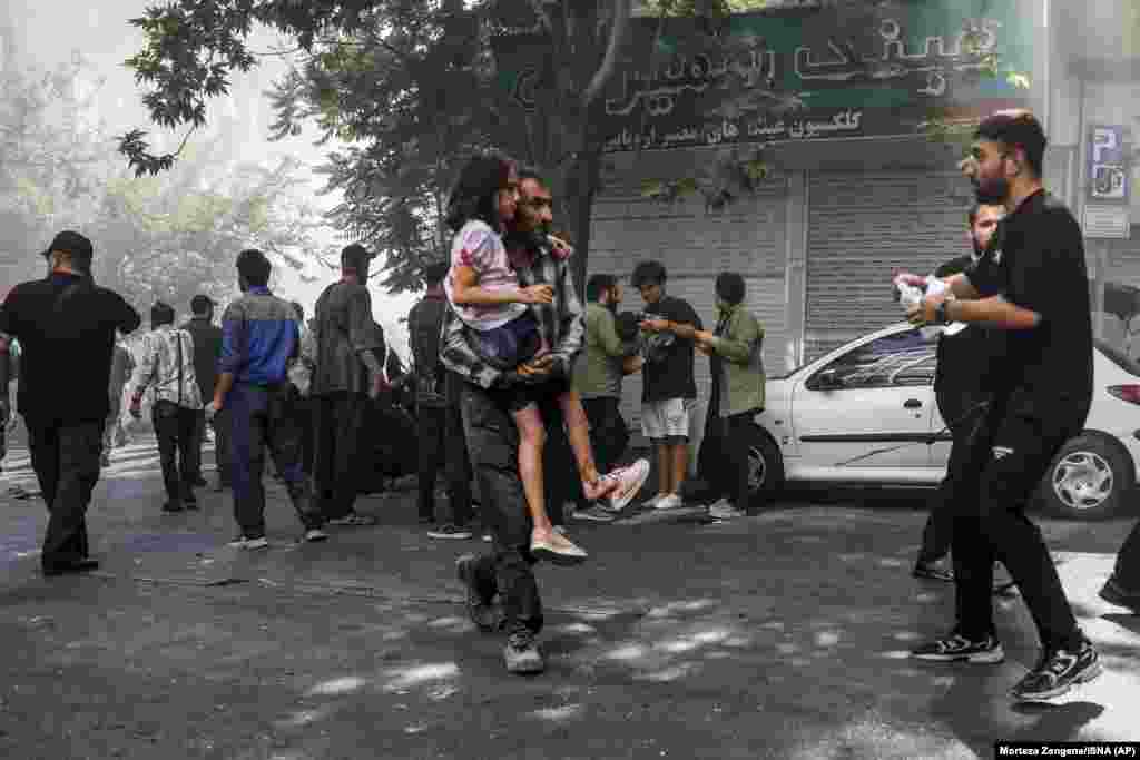 Një burrë duke bartur një vajzë të plagosur pas një shpërthimi në qendër të Teheranit, mes fushatës së vazhdueshme izraelite të sulmeve kundër Iranit, më 15 qershor.