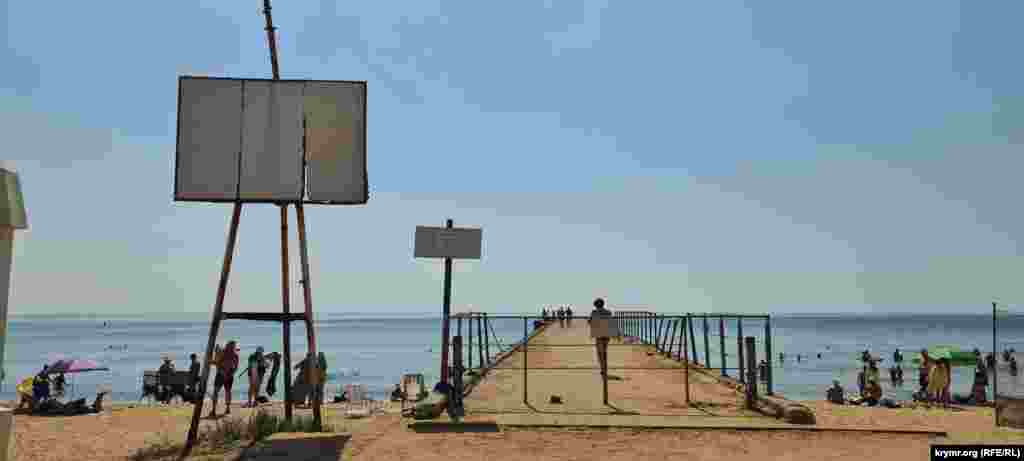 Аварийный причал на пляже, где несмотря на запрет гуляют люди
