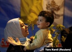 Žena s djetetom ispred katedrale Svetog Josipa pred papinu misu u ovoj crkvi, 6. mart, 2021.