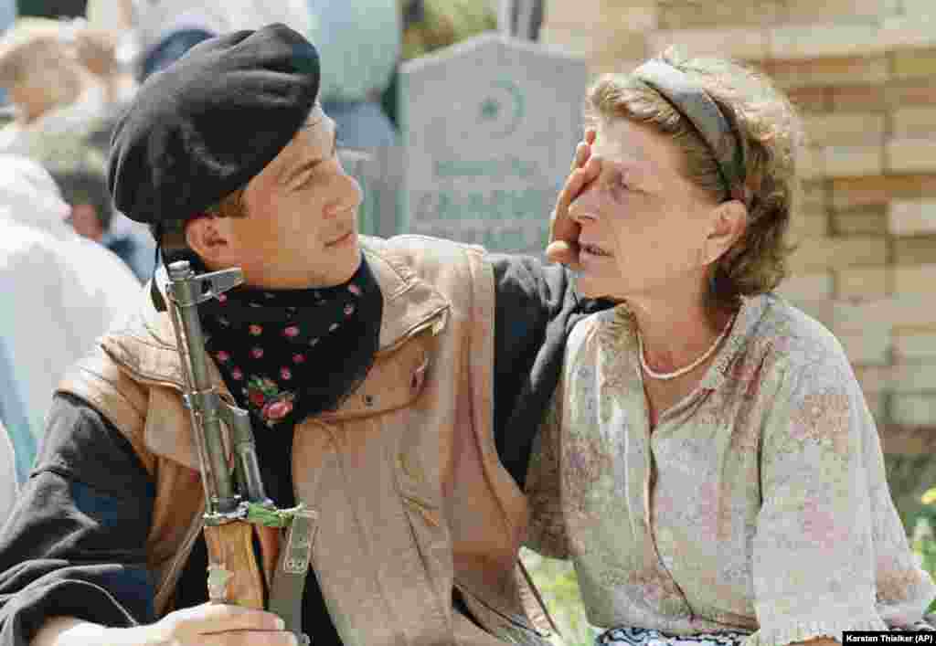 Bosanski vojnik, spreman da krene na prvu liniju fronta, briše suze majci ispred muslimanskog nadgrobnog spomenika u Rahiću, bosanskom gradu udaljenom 70 kilometara sjeverno od Tuzle, 28. april 1993.