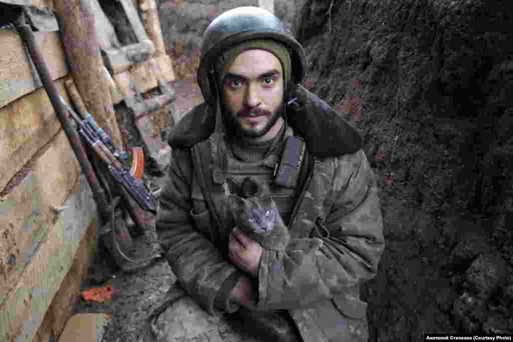 Vitalij, vojnik koga interno zovu Hans, drži mačku u rovu u blizini Želoboka u januaru 2020. Prvi put se pokušao pridružiti vojsci 2014., kada mu je bilo 16 godina. Nakon što ga je vojska odbila, tinejdžer je čekao dvije godine, te 2016. godine stupio u vojsku.