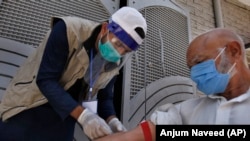 A health worker gets the blood sample of a person during door-to-door testing and screening campaign in Islamabad on June 15.