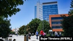Njerëzit kalojnë pranë ndërtesës së Kuvendit dhe Qeverisë së Kosovës. Prishtinë, 31 gusht 2021.
