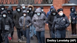 Policajac prati migrantske radnike koji su došli da obnove radne dozvole, Sankt Peterburg, Rusija, 2. april, 2020. 