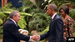 Президент Кубы Рауль Кастро (слева) пожимает руку президенту США Бараку Обаме, прибывшему на торжественный прием вместе с супругой Мишель в рамках визита на Кубу. Гавана, 21 марта 2016 года.