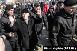 An elderly man is detained by police in Minsk.