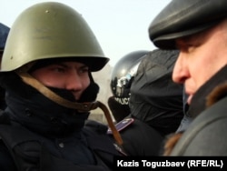 Лидер оппозиционной партии "Алга" Владимир Козлов разговаривает с полицейским на площади города Актау. 21 декабря 2011 года.