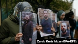 ფოტო არქივიდან: ხალხს ზელიმხან ხანგოშვილის ფოტოები უჭირავს თბილისში, გერმანიის საელჩოს წინ გამართულ საპროტესტო აქციაზე. 2019 წლის 10 სექტემბერი
