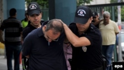 Турецкие полицейские арестовывают турецкого военного. 19 июля 2016 года.