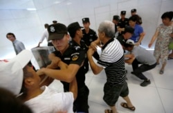 MH370-ის ჩინელი მგზავრების ახლობლები ცდილობენ შეაღწიონ მალაიზიის ავიახაზების ოფისში, პეკინი.2015 წლის 5 აგვისტოს.