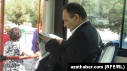 Человек читает газету в автобусе в Ашгабате. Иллюстративное фото.