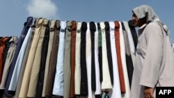 Афганский мужчина торгует на рынке одеждой секонд-хенд. Кабул, 7 августа 2013 года.