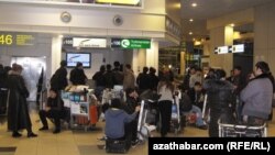 Пассажиры у стойки регистрации на рейс авиакомпании "Туркменские авиалинии" в московском аэропорту Домодедово.