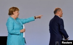 Talán ő lesz a következő vezető? Angela Merkel Olaf Scholz alkancellárra, az SPD pénzügyminiszterére mutat egy június 3-i sajtótájékoztatón